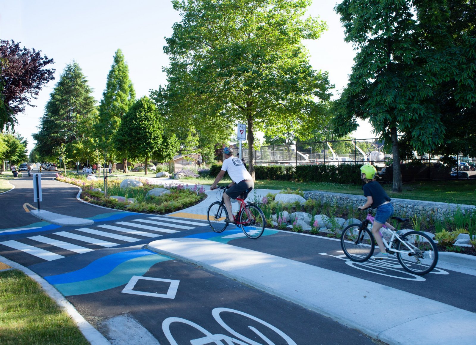 A street scene with trees, people, and traffic control